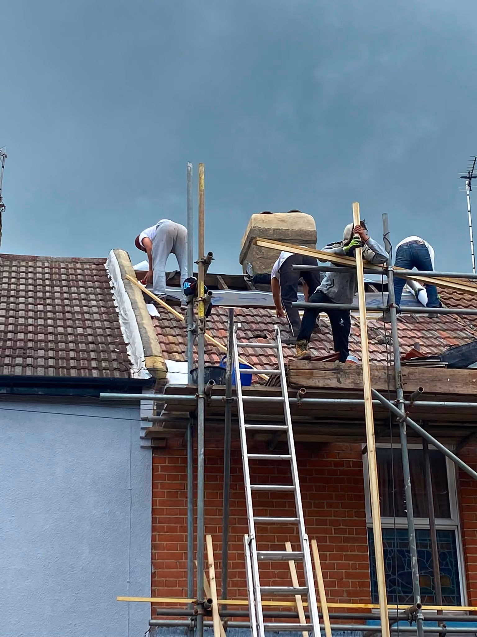 A terraced house with the roof stripped and underlay dressed over the front slope