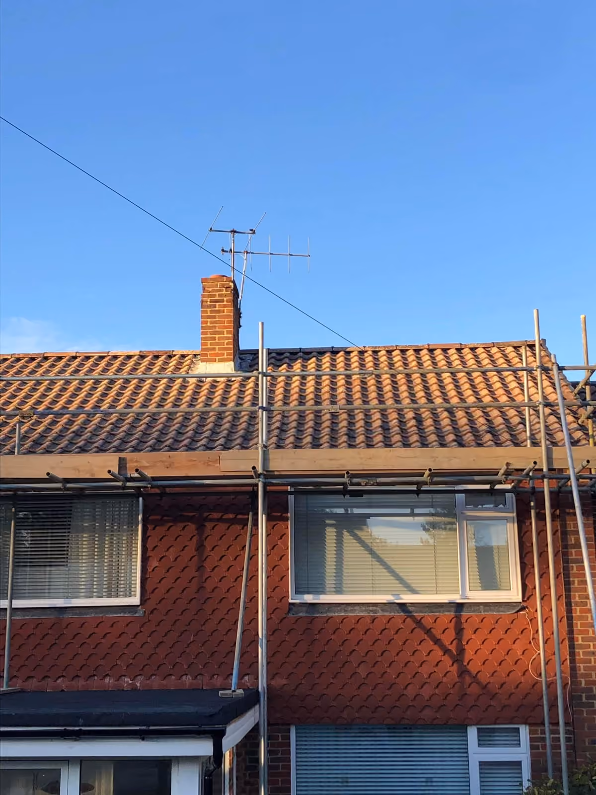 Tiled roof on a pair of semis with scaffold along the eaves