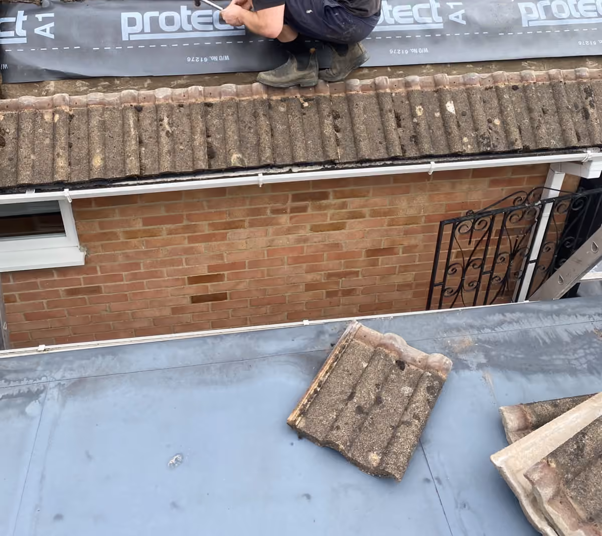 Underlay being dressed over the eaves before the battens go on